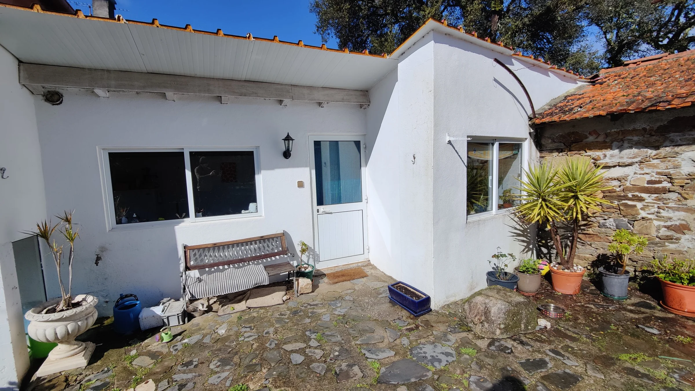 The exterior of the white guest annex and stone courtyard