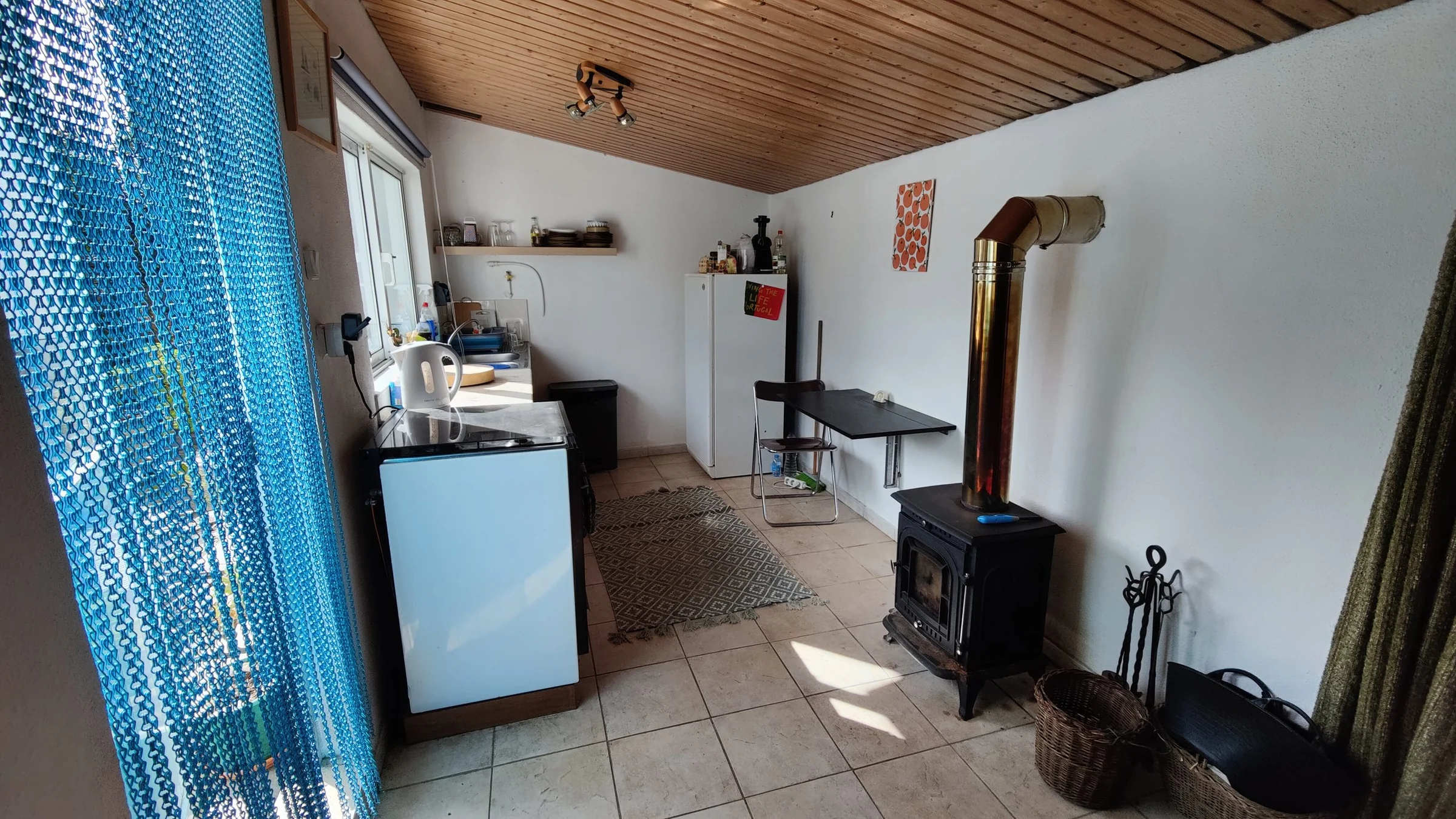 The kitchenette, fridge and wood burner inside the guest annex