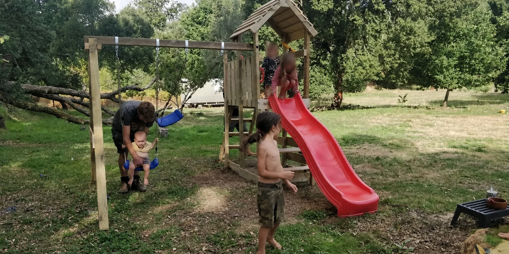 Children playing on the swings and slide beside the camping fields